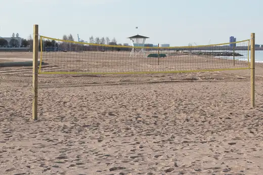 Volleyballnetz an einem Sandstrand vor dem Wasser